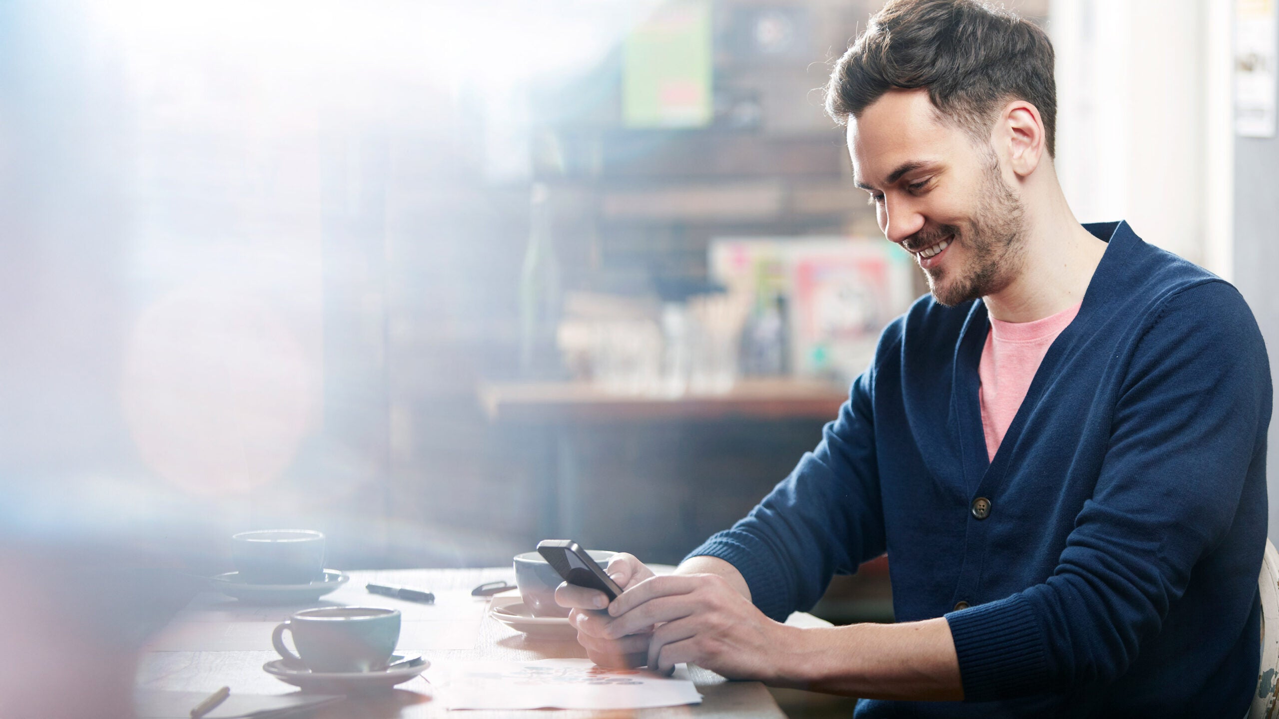 Man at desk looking a phone