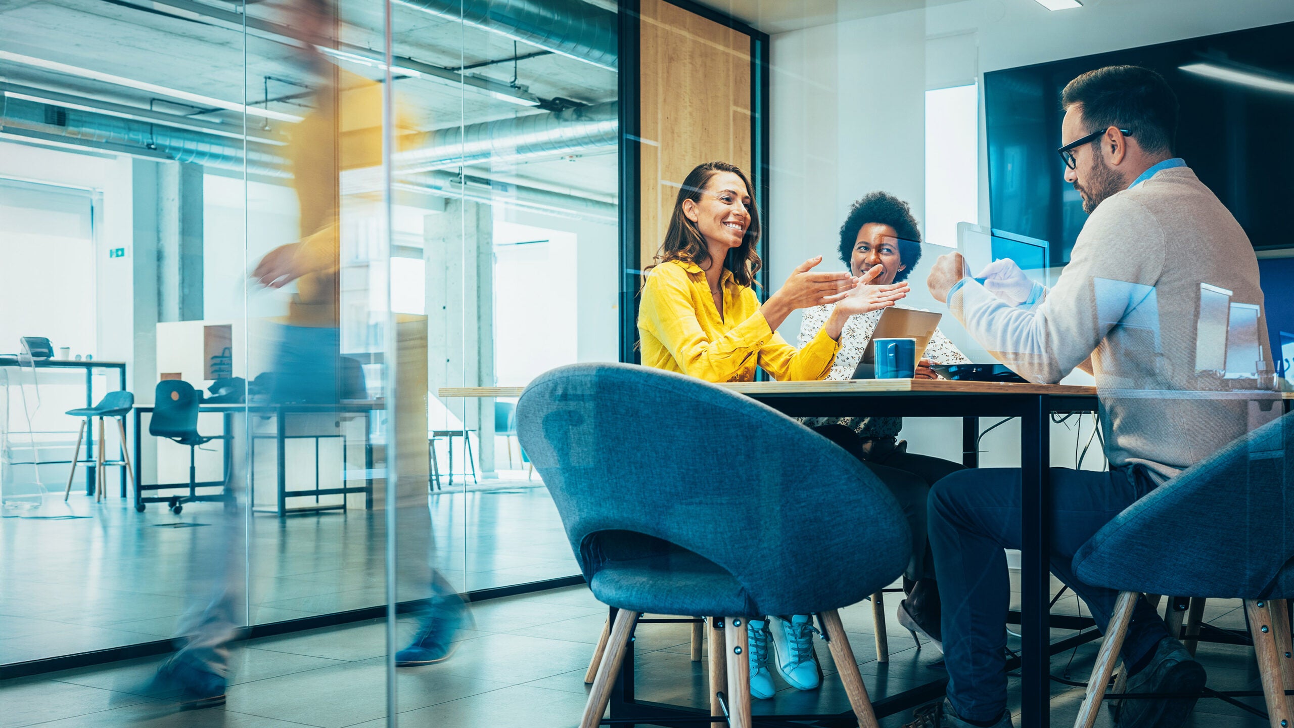 Man and two women sitting in conference room
