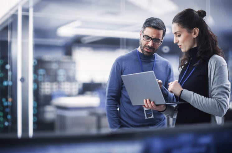 Man and woman working on laptop