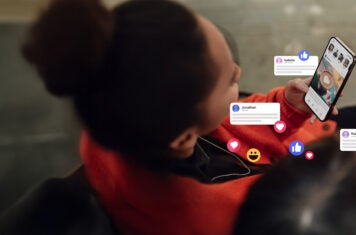Woman holding phone with social bubble popups